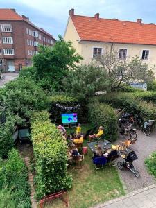 un groupe de personnes assises sur des chaises dans un jardin dans l'établissement Stor etage St knut, à Malmö