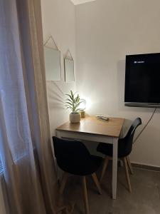 a table with two chairs and a television on a wall at Apartement Kingsize in Duisburg