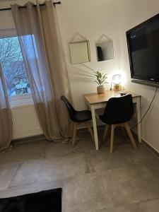 um quarto com uma mesa e duas cadeiras e uma televisão em Apartement Kingsize em Duisburg