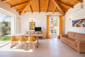een woonkamer met een tafel en stoelen en een bank bij Villa Chiara APT 2-Appartamento in villa con piscina in Cavaion Veronese