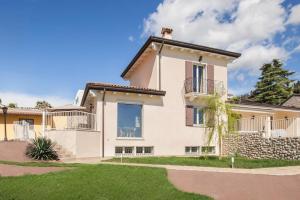 een groot wit huis met een tuin bij Villa Chiara APT 2-Appartamento in villa con piscina in Cavaion Veronese