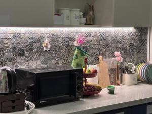 a microwave on a counter in a kitchen at Tranquil Haven Retreat - near Bangalore International Exhibition Centre in Nelamangala
