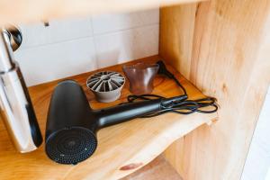 un apparecchio nero su una mensola in legno in cucina di Agriturismo Il Canto delle rane a Finale Ligure