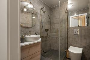 La salle de bains est pourvue d'une douche, d'un lavabo et de toilettes. dans l'établissement Sanhaus Apartments - Apartamenty Koral z parkingiem - 200 m od plaży, à Sopot