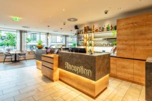 a restaurant with a reception counter and tables at CityClass Hotel am Dom in Cologne