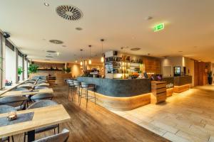 a restaurant with tables and chairs and a bar at CityClass Hotel am Dom in Cologne