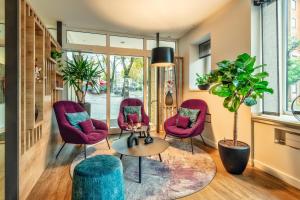 a living room with purple chairs and a table at CityClass Hotel am Dom in Cologne