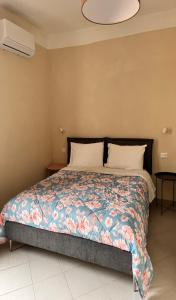 1 dormitorio con 1 cama con un edredón colorido en Collimare Rooms & Sailing near 5 Terre, en Vezzano Ligure