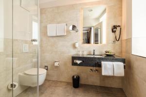 a bathroom with a toilet and a sink at CityClass Hotel am Dom in Cologne