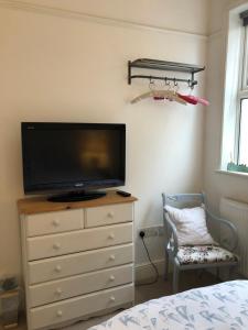 a bedroom with a dresser with a tv and a dresser with a bed at Puffin. Comfortable Annexe Central Falmouth in Falmouth