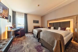 a hotel room with two beds and a desk at CityClass Hotel am Dom in Cologne