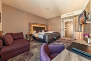 una camera d'albergo con letto e divano di CityClass Hotel am Dom a Colonia