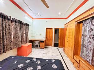 a room with a bed and a desk and curtains at 3BHK Vishwa Geeta Homes in Raipur
