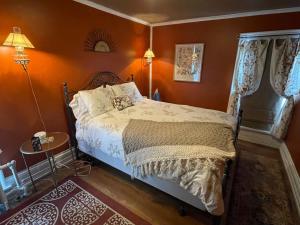 a bedroom with a bed with orange walls at Oscar's Inn in Buffalo