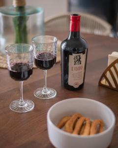 una mesa con dos copas de vino y un tazón de galletas en Vicoloterzo Suite, en Bari