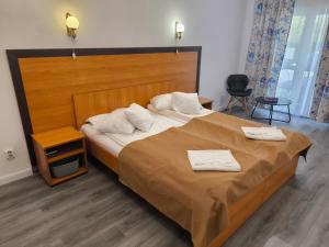 a bedroom with a large bed with two towels on it at Pensiunea Vila Chesa in Corunca