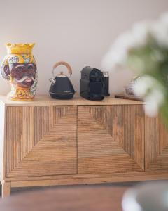 drewniana szafka z wazonem i telefonem w obiekcie Vicoloterzo Suite w mieście Bari