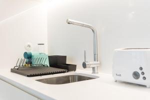 um balcão de cozinha com um lavatório e uma torneira em GuestReady - Cardosas Fourth no Porto