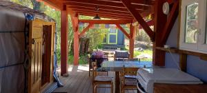un porche de una casa con mesa y sillas en Yourte au calme avec piscine, en Carbuccia