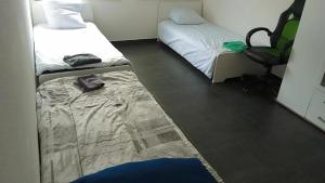 a room with two beds and a chair in it at Viva Zimmer in Heilbronn Zentrum in Heilbronn
