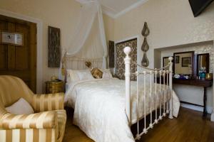 1 dormitorio con 1 cama blanca y 1 silla en Glenart House en Tramore