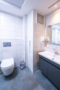 a white bathroom with a toilet and a sink at Formercity Termal Hotel in Eskisehir