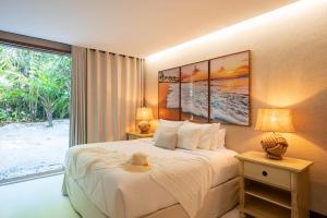 a bedroom with a bed and a large window at Casa 3A Tivoli Ecoresidences in Praia do Forte