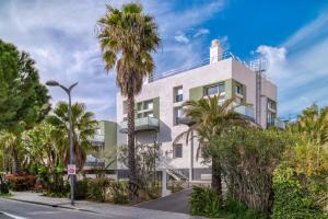 a building with palm trees in front of it at Nouvelle Ère - Appt à moins d’un km de la plage in Le Lavandou