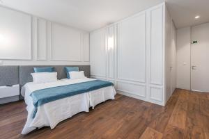 a bedroom with a large bed and white cabinets at GuestReady - Jardim das Oliveiras GuestHouse in Porto