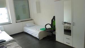 um pequeno quarto com uma cama e uma cadeira em Viva Zimmer in Heilbronn Zentrum em Heilbronn