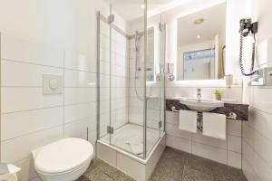 a bathroom with a toilet and a sink at CityClass Hotel am Dom in Cologne
