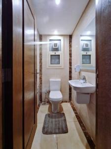 a bathroom with a toilet and a sink at Axxodia Residence New Cairo in Cairo