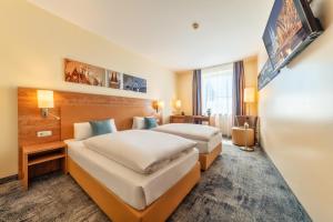 a hotel room with two beds and a tv at CityClass Hotel am Dom in Cologne