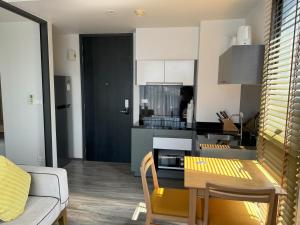 a kitchen and living room with a table and chairs at The Deck Condominium by Lofty in Patong Beach