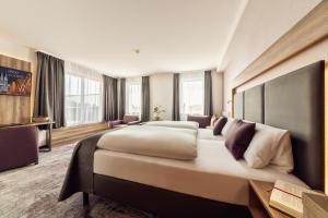 a bedroom with a large bed in a room with windows at CityClass Hotel am Dom in Cologne