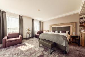 a hotel room with a large bed and a chair at CityClass Hotel am Dom in Cologne