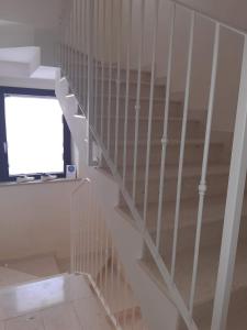a staircase with white rails in a room at Il Borgo Marinaro in Porto SantʼElpidio