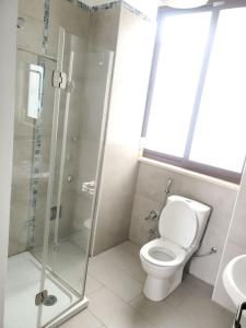 a bathroom with a toilet and a glass shower at YOLE Furnished Apartments in Addis Ababa