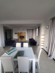 a living room with a white table and chairs at YOLE Furnished Apartments in Addis Ababa