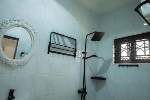 uma casa de banho com um chuveiro e um espelho. em CMP APARTMENTS em Kasoa