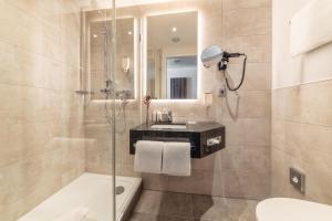 a bathroom with a shower and a sink and a toilet at CityClass Hotel am Dom in Cologne