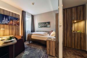 a hotel room with a bed and a desk at CityClass Hotel am Dom in Cologne
