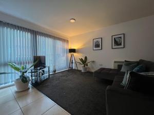 a living room with a couch and a television at Stunning City Centre Apartment, Benson Street, Liverpool 1 in Liverpool