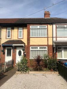 a brick house with a driveway in front of it at Two bedroom terrace house with parking in Hull