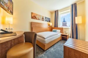 a hotel room with a bed and a desk at CityClass Hotel am Dom in Cologne