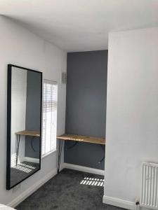 a dressing room with a mirror and a mirror at Two bedroom terrace house with parking in Hull