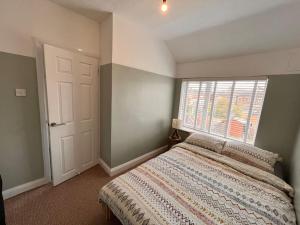 a bedroom with a large bed and a window at Two bedroom terrace house with parking in Hull