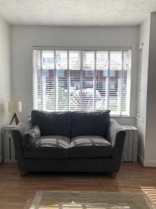 a living room with a couch in front of a window at Two bedroom terrace house with parking in Hull