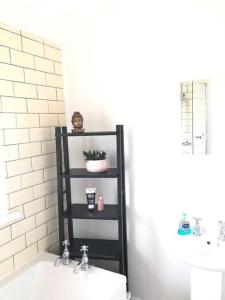 a bathroom with a black shelf next to a sink at Two bedroom terrace house with parking in Hull