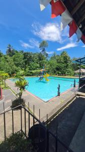 een zwembad met een speeltuin in een park bij RUMAH KAYU MATARAJA VILLA - TABANAN in Perean